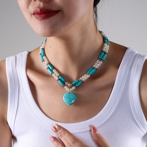 Close-up of double-layer turquoise and pearl beaded necklace with heart pendant