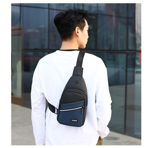 Detail of blue and black oxford chest bag featuring a functional earphone hole and zippers