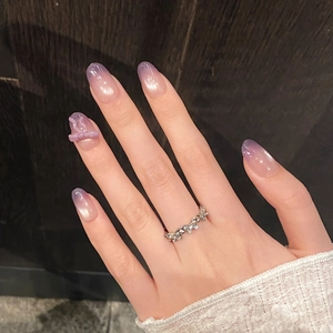 Close-up of wavy silver pavé ring with lilac gradient nails and bow accents