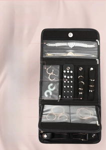 Detail of black jewelry organizer showing earring board, ring rolls and watch strap