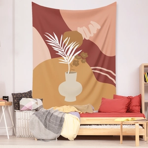 Detail of bohemian tapestry featuring abstract vases and palm leaves on a white wall