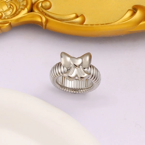 Détail macro d'une bague nœud argentée avec anneau torsadé sur un plateau blanc élégant