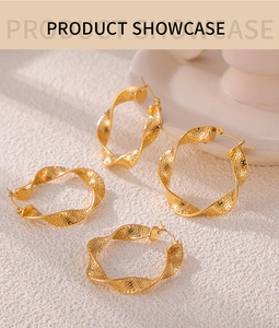 Macro detail of golden twisted hoop earrings with elegant spiral texture design