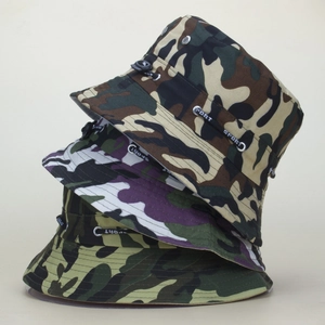 Close-up of stacked camouflage bucket hats showing different patterns and SPORT drawstrings