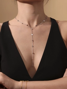 Détail du collier argenté en Y avec pendentifs cœur et zircons porté par un mannequin