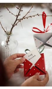 Detail of red polka dot Christmas envelope ornament with card on a fuzzy background