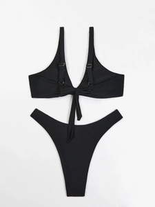 Dettaglio del top bikini nero con fiocco sulla schiena e slip sgambati stile minimalista