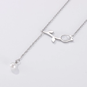 Collier tulipe argenté avec incrustation de nacre et pendentif perle sur fond minimaliste