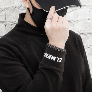 Close-up of men's mesh stainless steel bracelet and ring set in black and silver