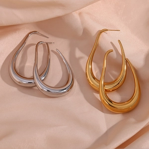 Detailed view of hollow curved hoop earrings in polished gold and silver finishes