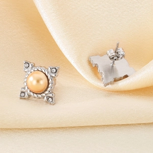 Detail of square vintage earring with champagne pearl, white crystals and silver rope texture