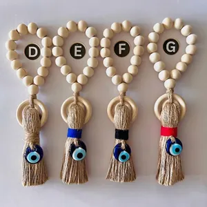Bohemian Evil Eye door hanger with wood beads and colorful yarn tassels on white background