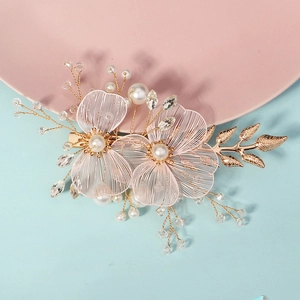 Detail of handmade bridal hair clip with gold metal flowers and white pearls