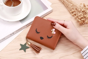 Detail of a brown leather coin purse featuring a cute animal face and pink bow decoration