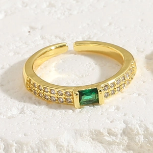 Detailed macro view of 18K gold adjustable ring with emerald-cut green zircon and pavé side stones