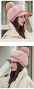 Detail view of pink plush winter hat with ear flaps and fluffy pompom from two side angles