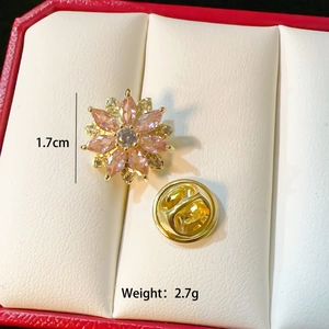 Macro detail of a 1.7cm flower brooch with pink gems and gold plating on jewelry box