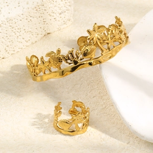 Detail view of 18K gold plated hollow sea shells and starfish jewelry set on white rock
