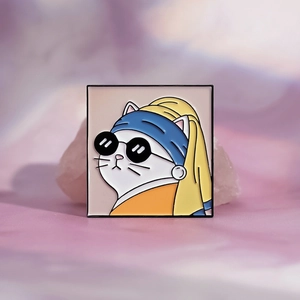 Cartoon cat wearing pearl earring enamel pin with sunglasses on a stone background