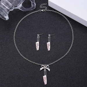 Detailed shot of silver cleaver pendant necklace and earrings with Killing It engraving