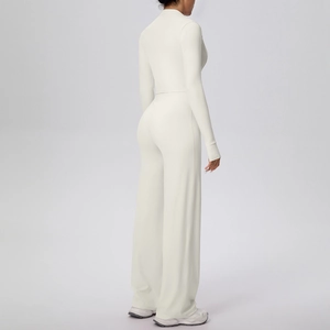 Détail de l'ensemble de yoga blanc crème avec pantalon large taille haute et veste ajustée