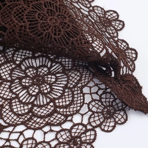 Détail du tissu en dentelle marron foncé avec motifs floraux vintage et maille ajourée