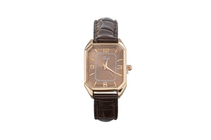 Close-up of rectangular rose gold watch face with brown crocodile leather strap