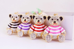 Close-up of sparkling crystal bear keychains with colorful striped sweaters and gold plating