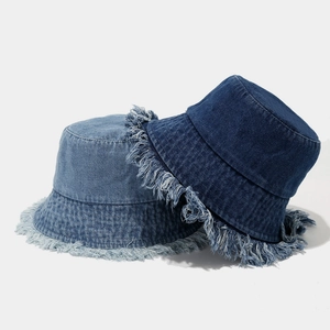 Set of light and dark blue distressed denim bucket hats with frayed edges and retro style