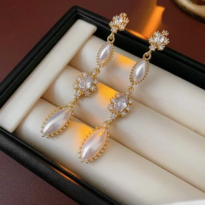 Detail of vintage gold tassel earrings with iridescent marquise pearls and crystals