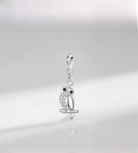Detailed close-up of a silver owl pendant with sparkling micro-paved crystals and black eyes