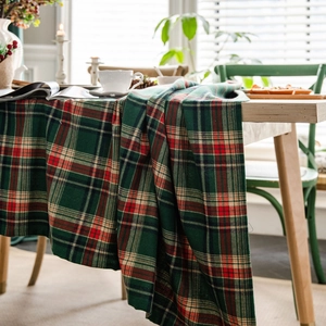 Green and red Scottish plaid tablecloth in a cozy festive home setting by a window