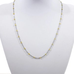 Detail view of a silver stainless steel bead chain necklace with yellow enamel dots