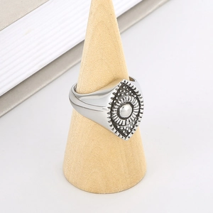 Close-up of vintage steel sunburst ring with devil's eye detail on a wood stand