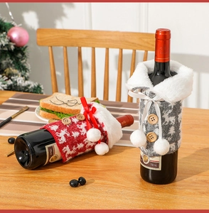 Knitted Christmas wine bottle covers with reindeer motif and faux fur on a festive table