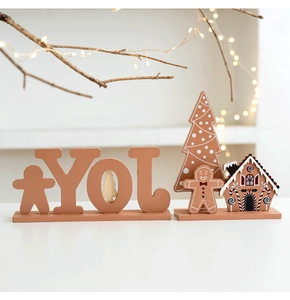 Detail of wooden Christmas gingerbread house and JOY letter ornaments with warm LED lights