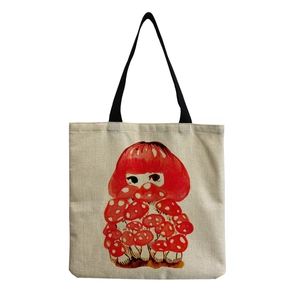 Detailed view of stylized red mushroom girl print on a beige canvas tote bag