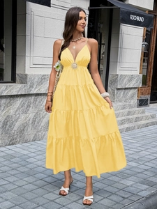 Eleganter gelber V-Ausschnitt Maxikleid mit Stufenrock-Detail in einer Straßenkulisse