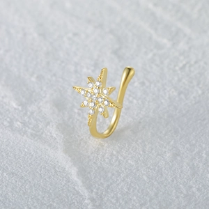 Close-up of gold eight-pointed star nose cuff with shimmering cubic zirconia stones