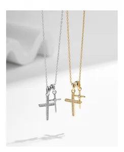 Gros plan du collier pendentif double croix en or et argent orné de zircons cubiques
