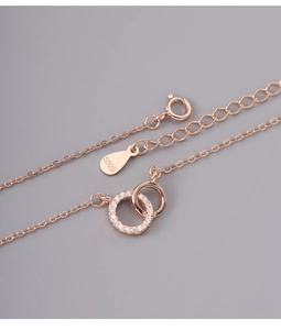 Detailed close-up of 925 sterling silver S925 stamp on rose gold double ring necklace