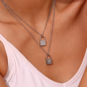 Silver double-layer chain necklace with two lock pendants worn by a model