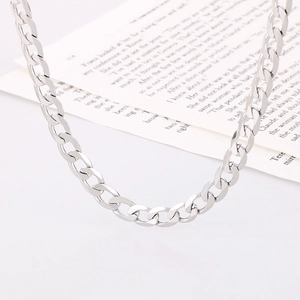 Macro shot of polished silver curb chain links on a vintage paper background