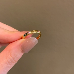 Dettaglio anello stella dorato con zirconi colorati e motivi celesti incisi