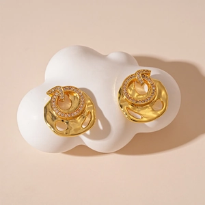 Detail of gold zircon studs with irregular hammered texture on white display