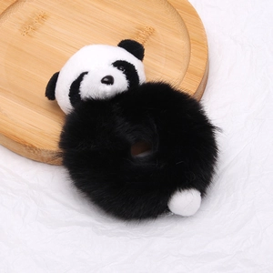 Gros plan d'un chouchou panda en peluche avec texture douce sur plateau bois