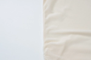 Macro shot of breathable beige mesh fabric showing fine texture and soft draping details