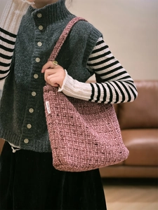 Dettaglio della borsa a spalla in tweed rosa spesso testurizzato con trama in tessuto intrecciato