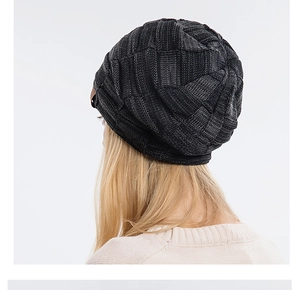 Detail of dark grey knit beanie featuring a thick checkered texture and leather side label