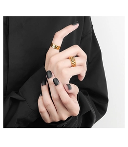 Close-up of golden croissant twist ring and polished double-line band on model hand